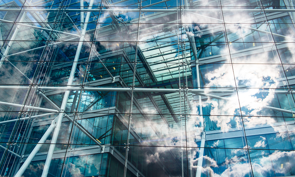 wall of window panes reflecting a blue cloudy sky