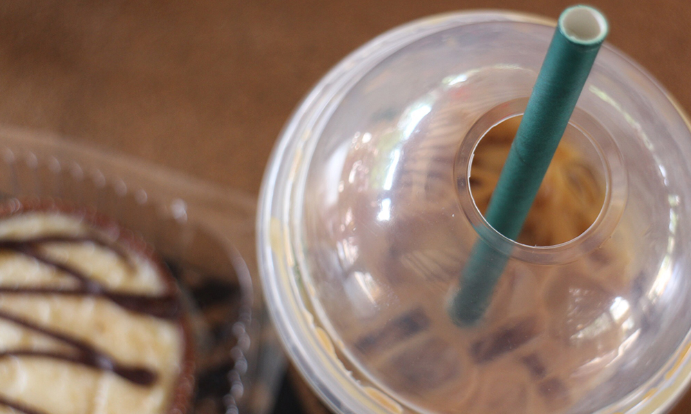 a closeup of an iced Starbucks beverage with one of their new cardboard straws