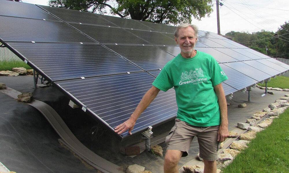 Don Priester posing in front of his solar panels
