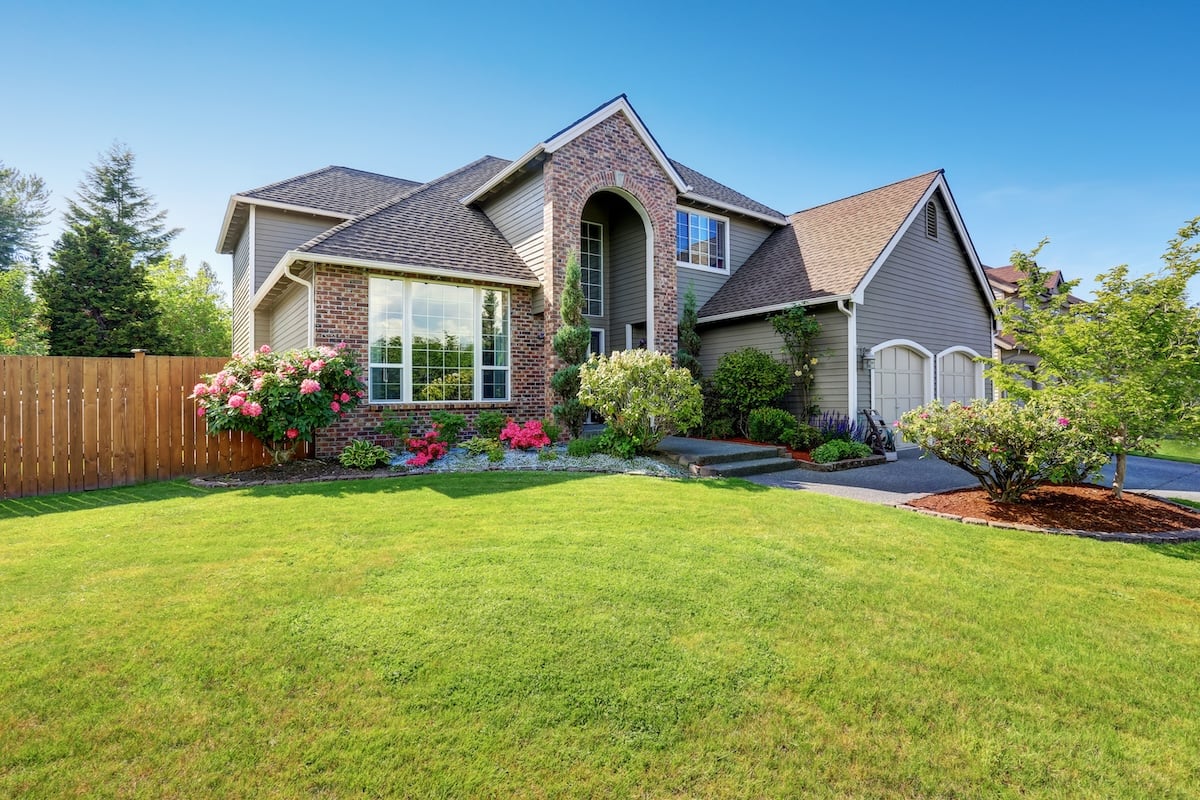 Luxury house exterior with brick and siding trim and double garage and new roofing system