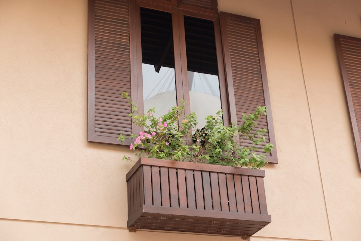 brown wooden window with tinted glass decorating with flowerpot