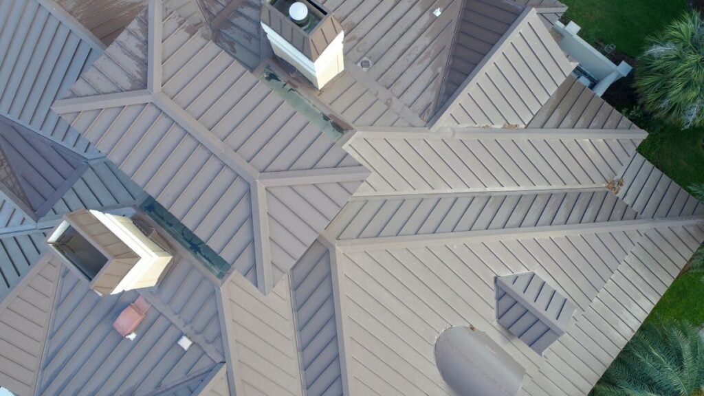 aerial view of a big house with grey standing seam metal roof