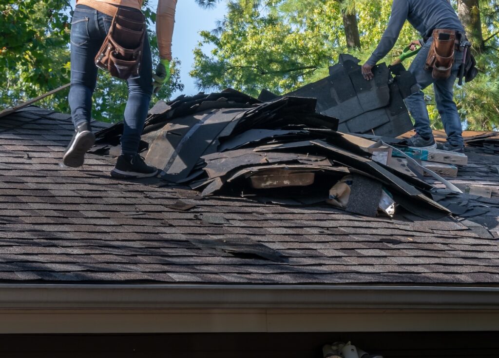 tearing off storm damage shingles