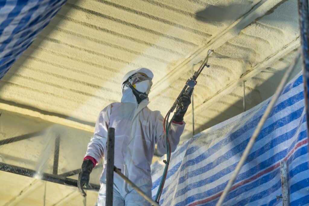 industrial roof insulation worker spreading foam