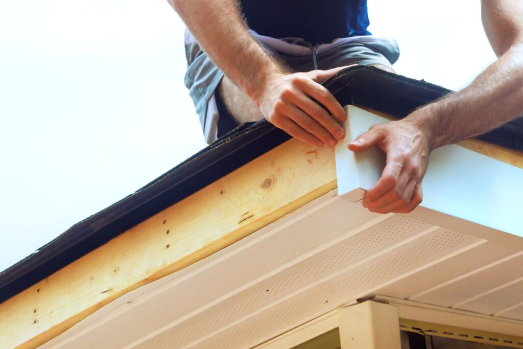 metal roof trim worker installing white aluminum sheet