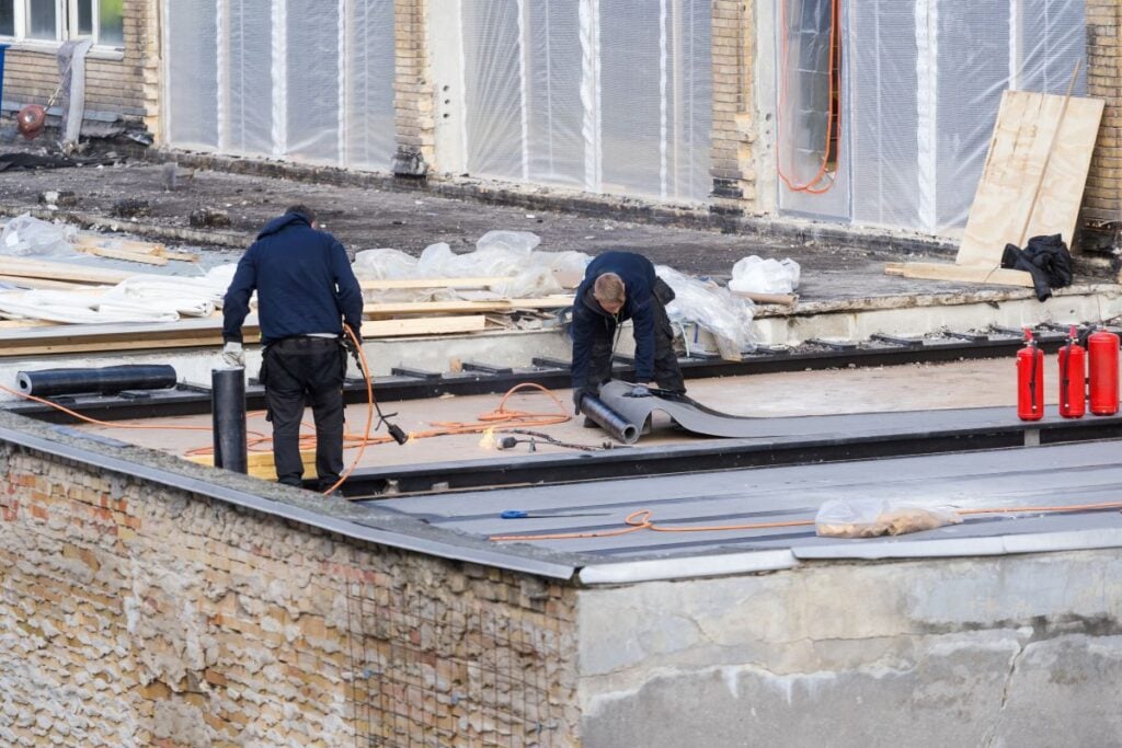 flat roof replacement workers replacing EDPM