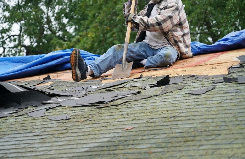 how long does a roof replacement take worker removing shingles with a shovel
