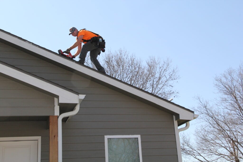 roof replacement financing guy on top of roof removing shingles